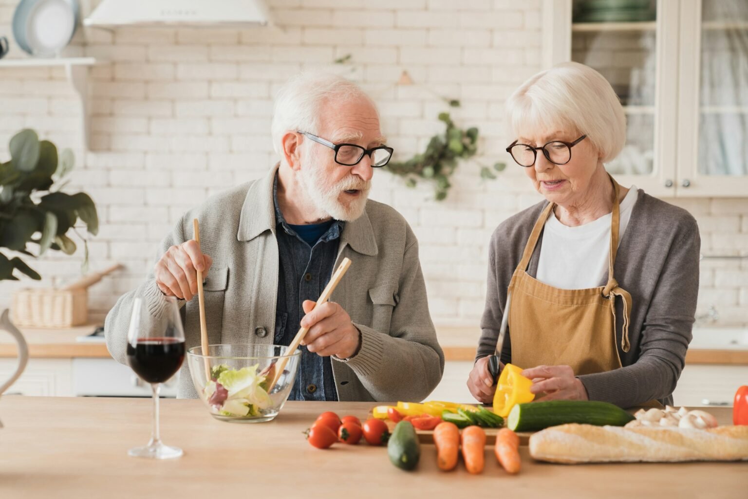 Grandparents cooking together at home kitchen making vegetable vegan food meal salad. Healthy eating